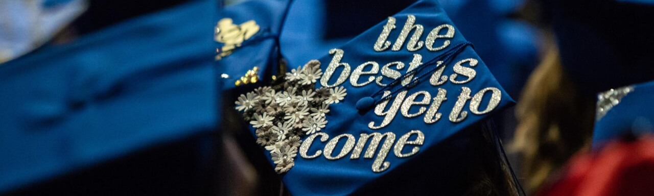 A student's graduation cap reads "The best is yet to come"